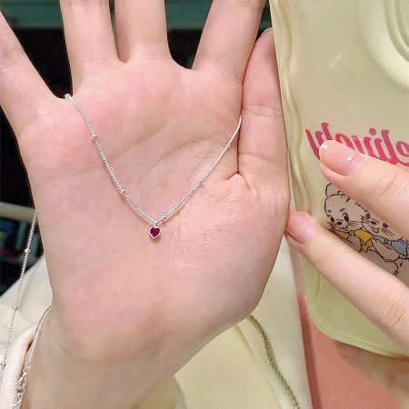 Another view of the sterling silver necklace with a heart-shaped red gemstone pendant.