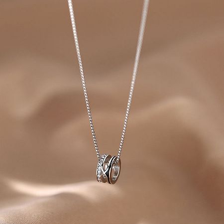 Detailed view of the silver choker with an interlocking circle pendant, one circle adorned with sparkling zircons.