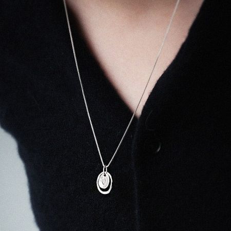 Model wearing the sterling silver necklace with an interlocking circle pendant.