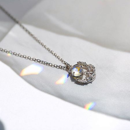 Detailed view of a sterling silver necklace with a large, brilliant iridescent gemstone pendant.