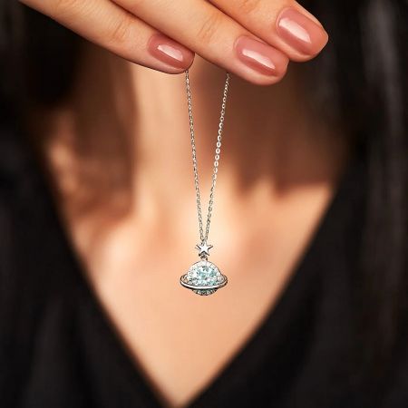 Detailed view of the cosmic necklace pendant with a light blue zircon stone.