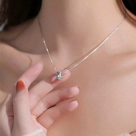 A model showcasing the silver choker with an oval zircon pendant, highlighting its shine against the skin.
