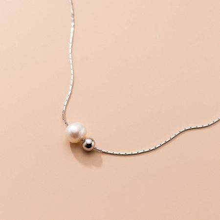 Detailed view of the pearl and silver bead on the 925 sterling silver necklace.