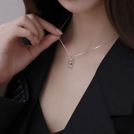 Silver enchanted rose pendant necklace worn to showcase its elegant drop.