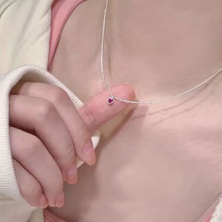 Model wearing the sterling silver necklace with a purple heart zircon pendant.