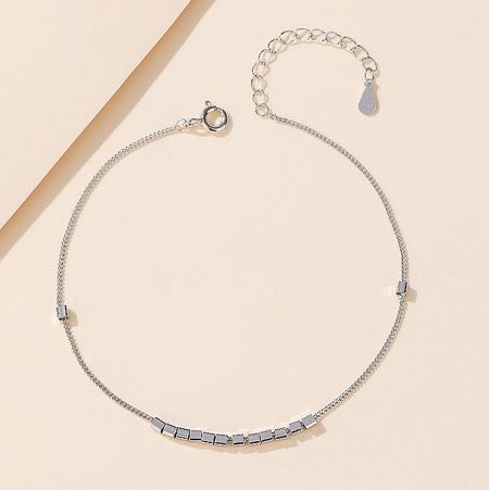 Close-up of a silver bracelet with seven small rectangular pieces, showcasing the fine craftsmanship.