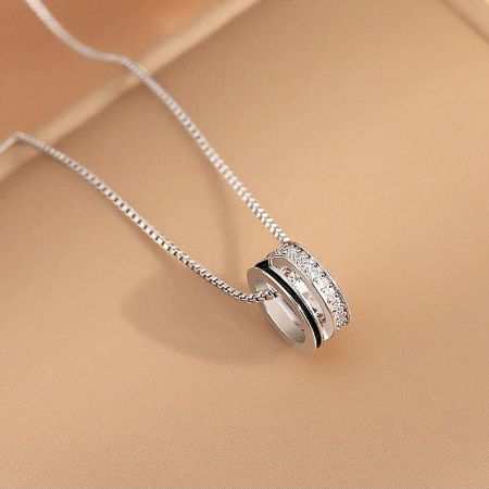 A minimalist silver necklace from the set with a single sparkling stone pendant.