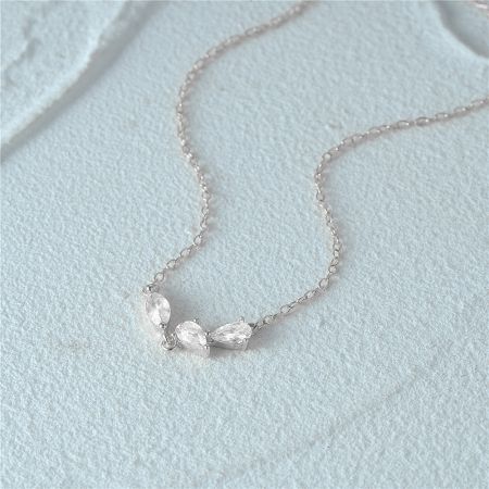 A clear product shot of the silver necklace with its three-stone zircon pendant.