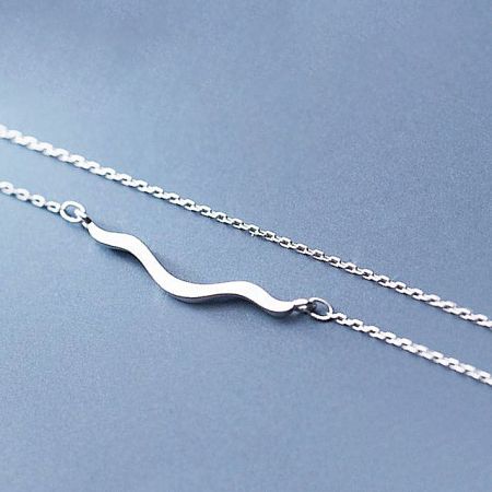 Full view of the simple coastline wave necklace on a chain.