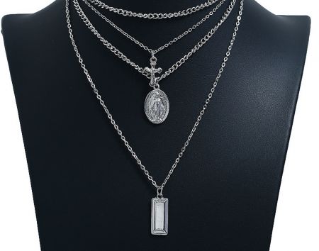 Display of custom religious necklaces available in sterling silver, demonstrating material versatility.