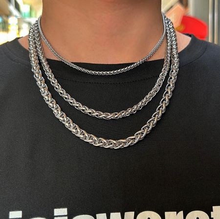 Two twisted rope chain necklaces worn on a mannequin with a black shirt to show how they look.