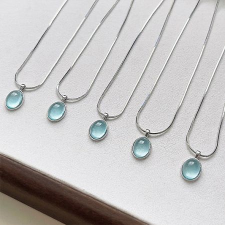 A set of elegant silver-plated costume necklaces featuring pale green glass dome pendants.