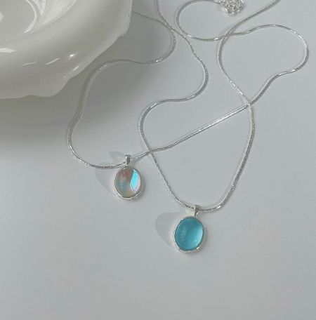 Close-up view of two sterling silver opal necklaces with distinct oval pendants.