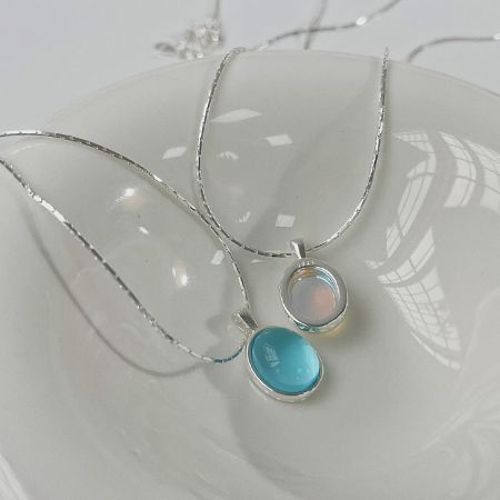 Detailed shot of two silver necklaces highlighting the unique pendant stones.