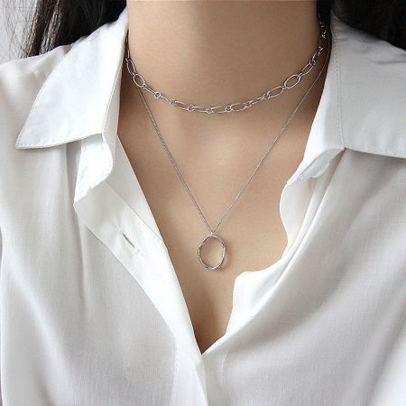 The 925 sterling silver version of the irregular oval pendant necklace worn by a model, highlighting its versatility.