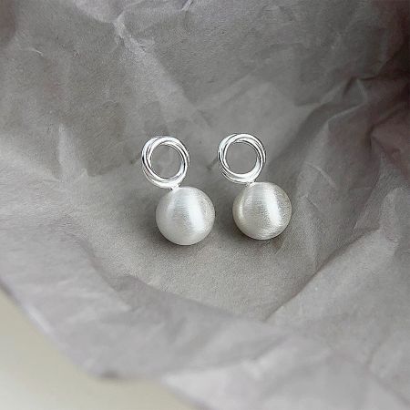 Angled view of the pair of matte silver 3D ball stud earrings highlighting the spherical shape.