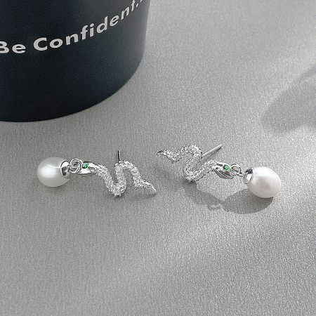 Detailed shot of the sterling silver snake earring showing the texture and green accent stones.