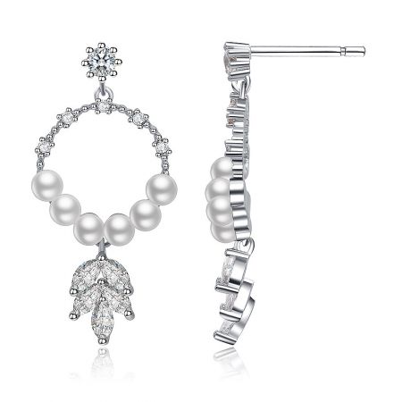 Detailed view of the silver metal chandelier earrings showcasing the intricate leaf design with pearls and clear gemstones.