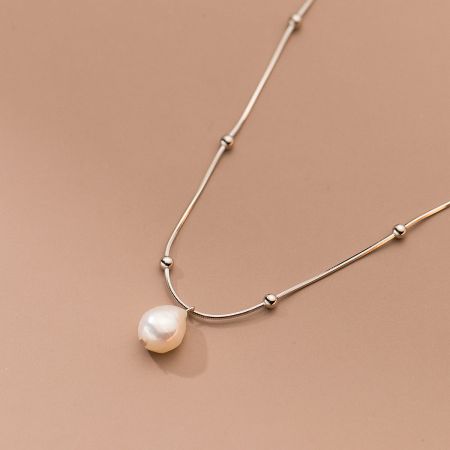 The sterling silver baroque pearl necklace displayed on a neutral background, showing its timeless appeal.