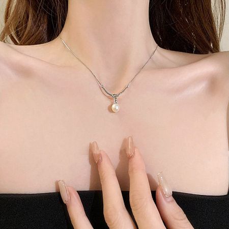 Detailed view of the silver-plated pearl pendant necklace, highlighting the knot design.