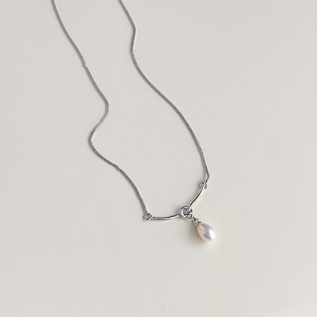 A simple and elegant silver necklace with a single white pearl pendant, shown against a white backdrop.