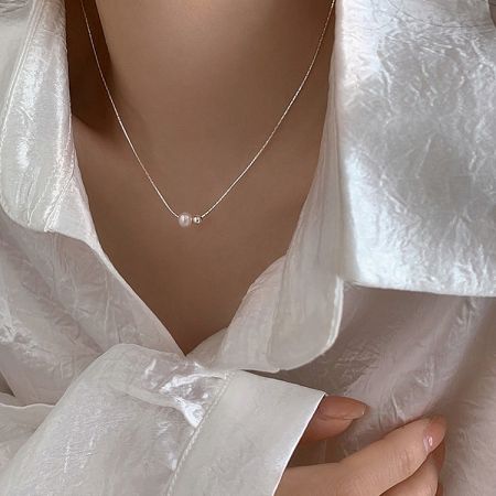 Model wearing the sterling silver two-pearl necklace, showcasing its elegant fit.