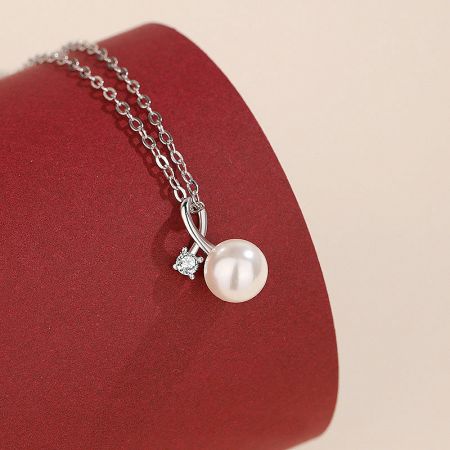 925 Sterling Silver Pearl and Cubic Zirconia Pendant Necklace - A close-up of a 925 sterling silver necklace featuring a classic white pearl pendant accented with a brilliant, sparkling cubic zirconia charm.
