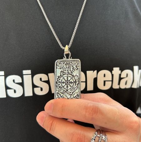 Side view of the silver-toned tarot pendant, highlighting its unique and detailed design.