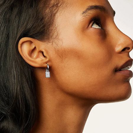 A woman wearing the silver celestial square charm dangle earrings, shown from the side profile.