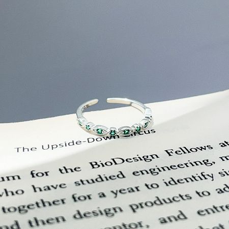 Detailed view of the 925 sterling silver open stacking ring with delicate green zircon stones.