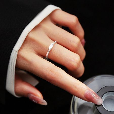 A model's hand wearing the adjustable 925 sterling silver twisted rope ring, showcasing its elegant fit.