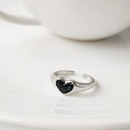 Silver Plated Black Enamel Heart Open Finger Rings (Set of 5) - Close-up of a silver-plated ring with a black enamel heart, part of a five-piece set, displayed on a white saucer.