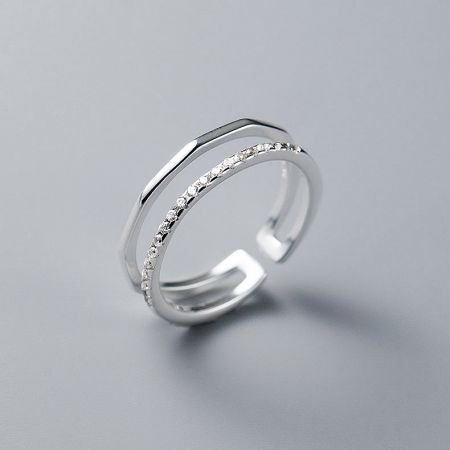 Detailed view of a sterling silver adjustable ring with a dual-band design and diamond-like embellishments.