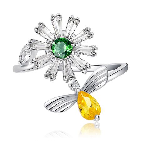 Spinning Flower Bee Ring - Close-up of the Spinning Flower Bee Ring, showcasing the central green CZ stone in a floral setting and a yellow CZ bee accent on a rhodium-plated brass band.