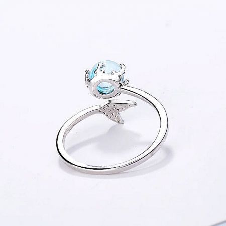 A 925 sterling silver ring with a light blue gemstone and a delicate star accent on the band.