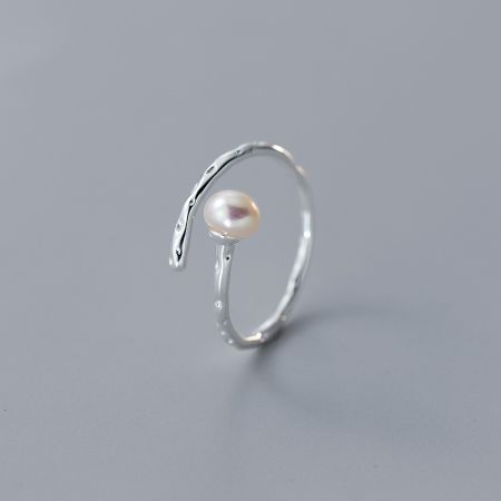 Set di anelli regolabili in perla da 5 pezzi in argento sterling 925 all'ingrosso. - Un primo piano di un elegante anello regolabile in argento sterling 925 di un set femminile, con una prominente perla bianca su una fascia unicamente testurizzata.