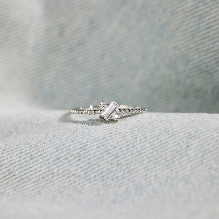 Detailed view of the asymmetric design of the sterling silver cross ring.