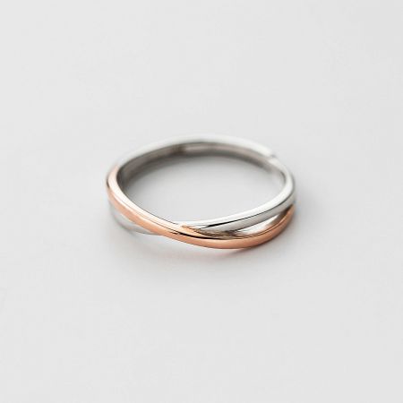 A minimalist silver Möbius ring with a subtle rose gold twist accent, showcasing its modern design.