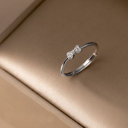 S925 Dainty Cubic Zirconia Bow Ring Set of 5 - A close-up of the S925 sterling silver bow ring with three sparkling cubic zirconia stones.