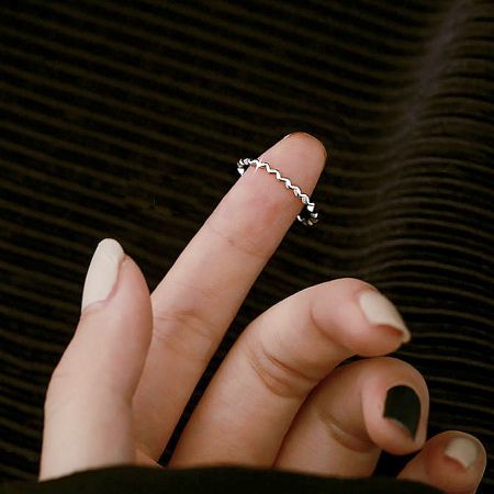 Detailed product shot of a silver ring from the set, highlighting the wavy band and ball detail.