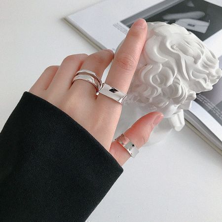 Multiple minimalist 925 sterling silver rings from the geometric set stacked on a hand, demonstrating a trendy Korean-inspired look.