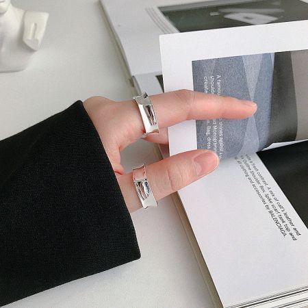 A hand wearing two geometric 925 sterling silver rings, showcasing their minimalist style for everyday women's fashion.