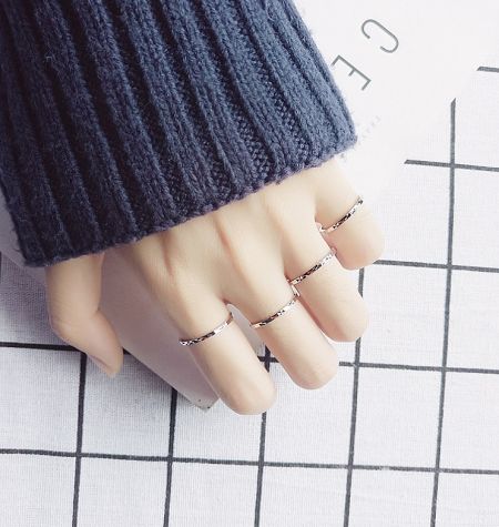 Four 925 sterling silver diamond cut rings displayed on a mannequin hand.