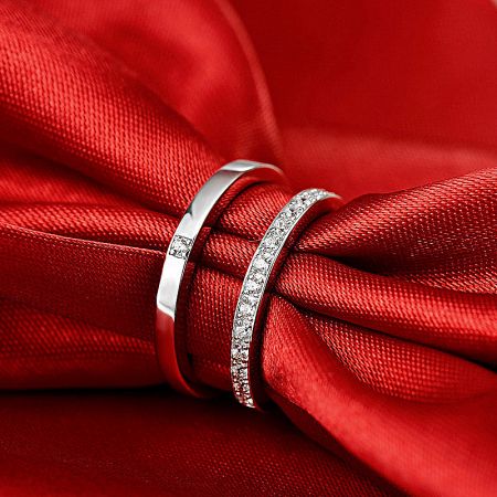 The matching 925 silver ring set displayed on a rich red fabric.