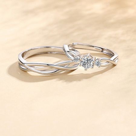 999 Sterling Silver Couple Rings Set with Twisted Design - A stunning pair of 999 sterling silver couple rings with a twisted design, the women's ring featuring a brilliant central cubic zirconia stone.