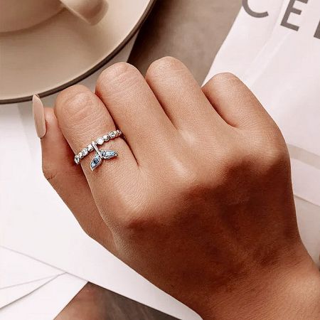 A stylish look at the sterling silver ring set, including the butterfly design, worn on a hand.