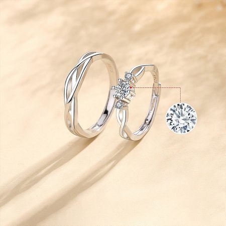 Elegant 999 sterling silver couple rings set displayed with a loose cubic zirconia stone to highlight its brilliance.