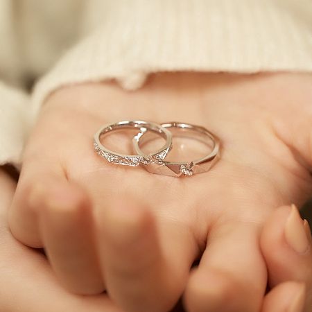 Another lifestyle shot showing the his-and-hers sterling silver wedding bands on a hand.