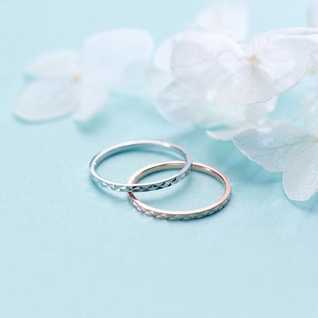 The sterling silver stackable rings displayed elegantly with white flowers.