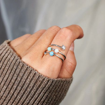 A model wearing the Starlit Ocean 925 sterling silver opal and zircon rings on her finger.
